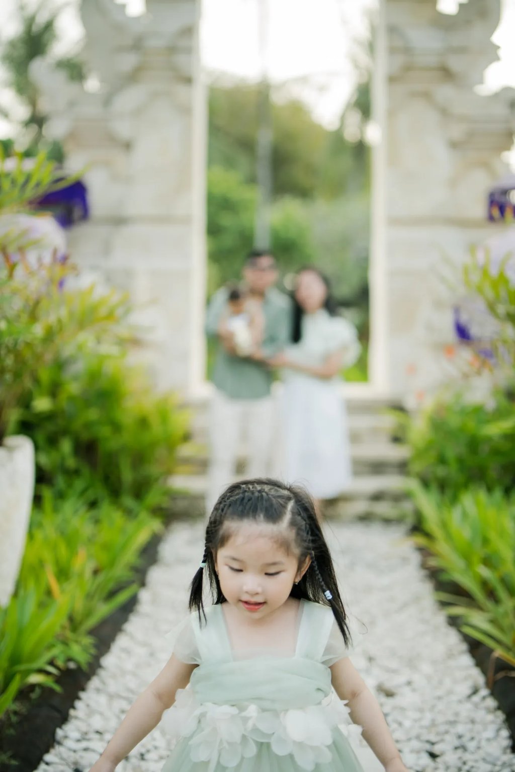 Family standing at a traditional Balinese gate during a family photography session in Nusa Dua Bali.