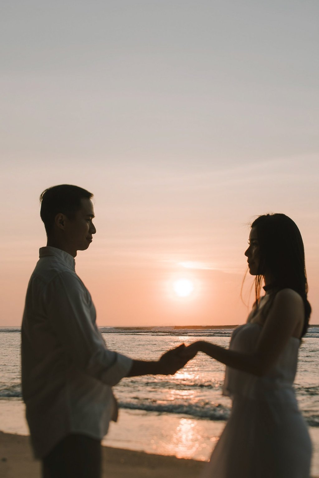 Silhouette couple holding hands at sunset during a proposal photography session at Anantara Uluwatu Bali Resort.