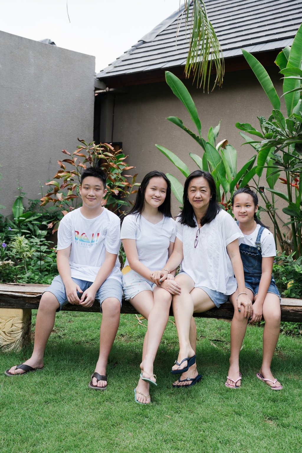 Family sitting together during extended family photography session at Lumbini Villas Jimbaran Bali in garden setting