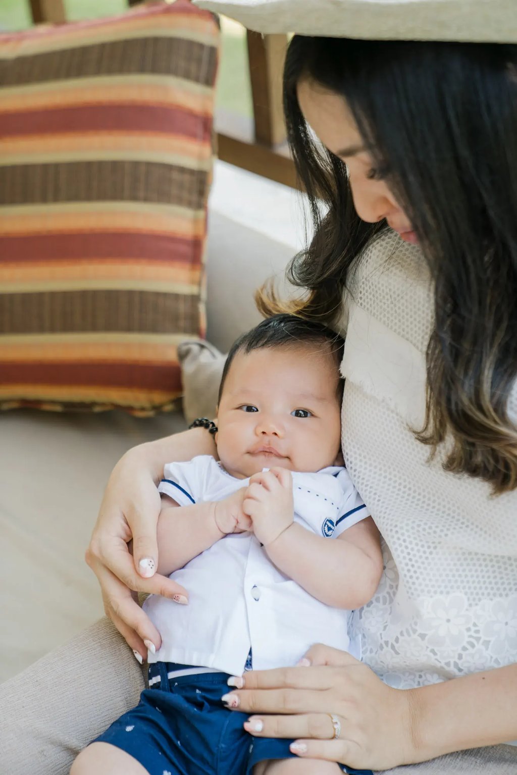 Mother holding her baby during a family photography session at Samabe Bali Suites & Villas in Nusa Dua.