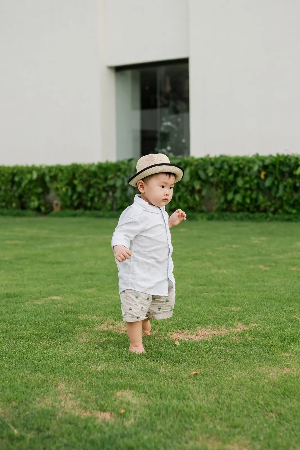 Baby playing on lawn at Alila Seminyak Bali during relaxed luxury family photography session.