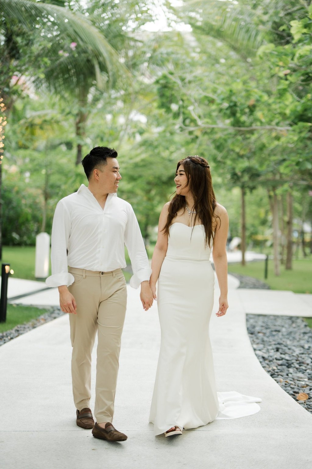 Couple walking together along a tropical garden path during a prewedding session at Apurva Kempinski Bali