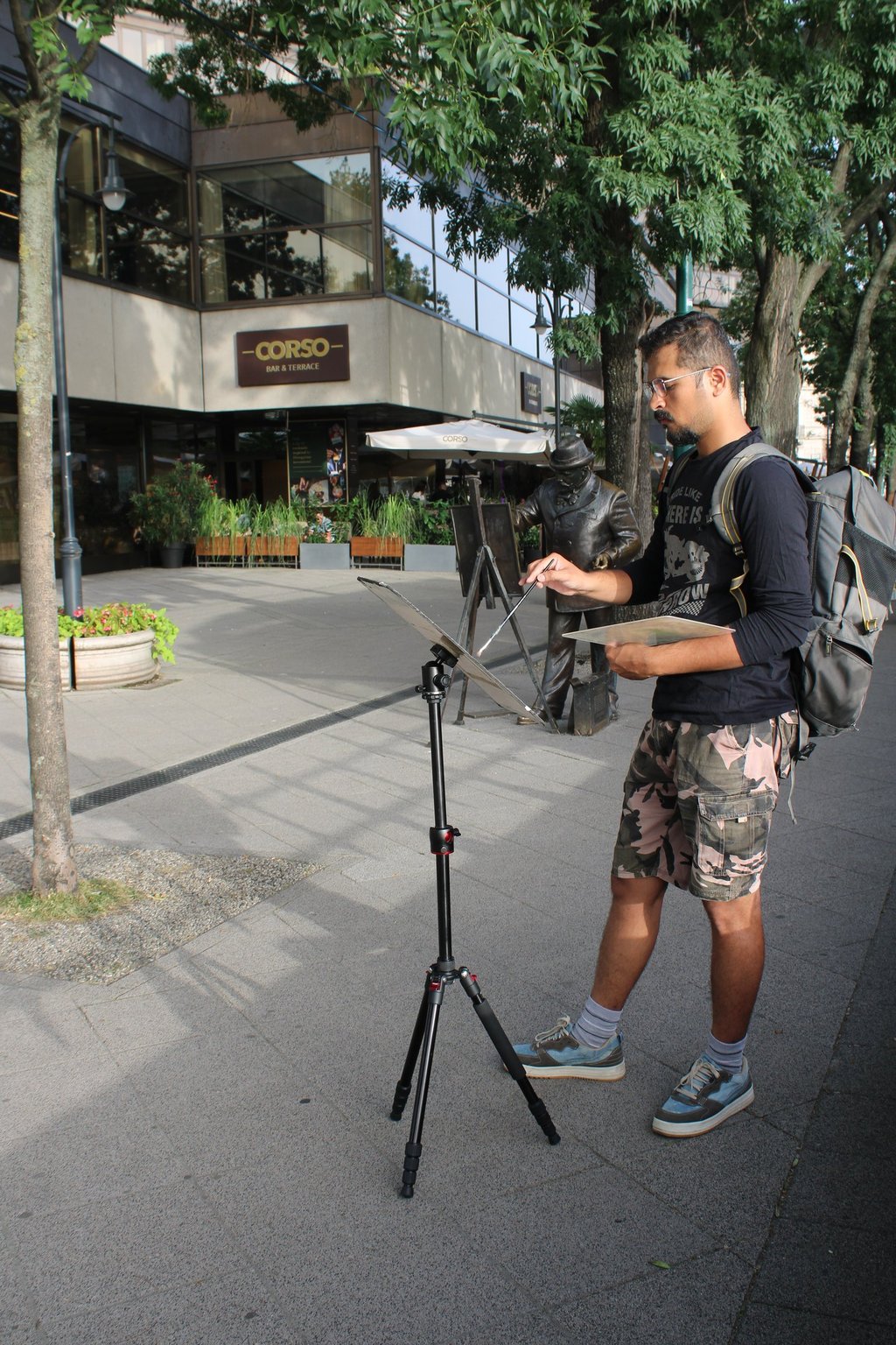 Sanket standing outdoors with a city square behind him