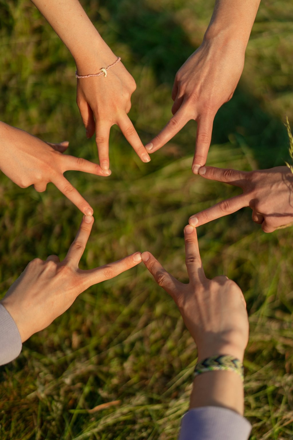 6 manos unidas con símbolo victoria