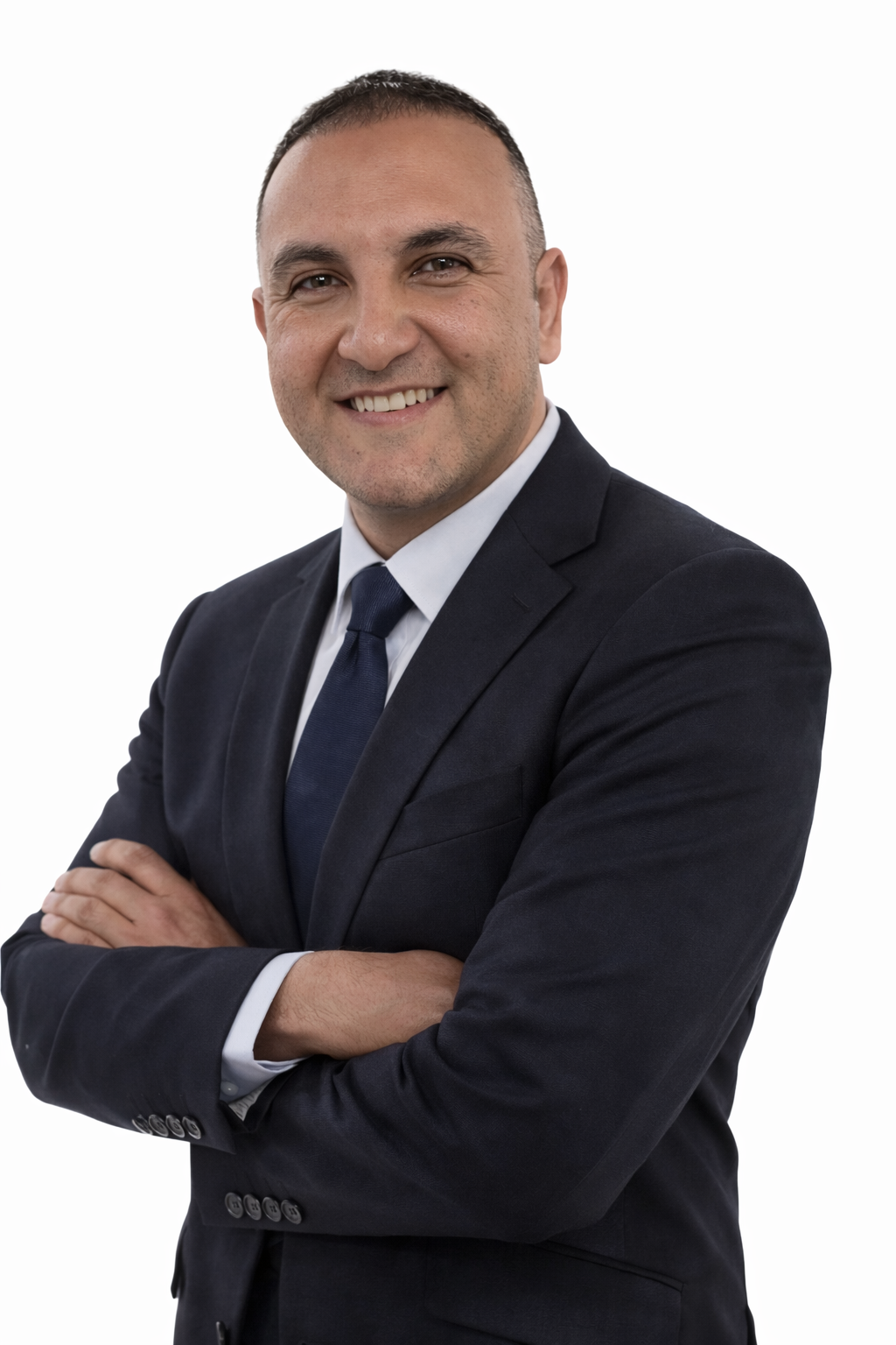 A smiling professional businessman in a navy blue suit and tie with arms crossed.