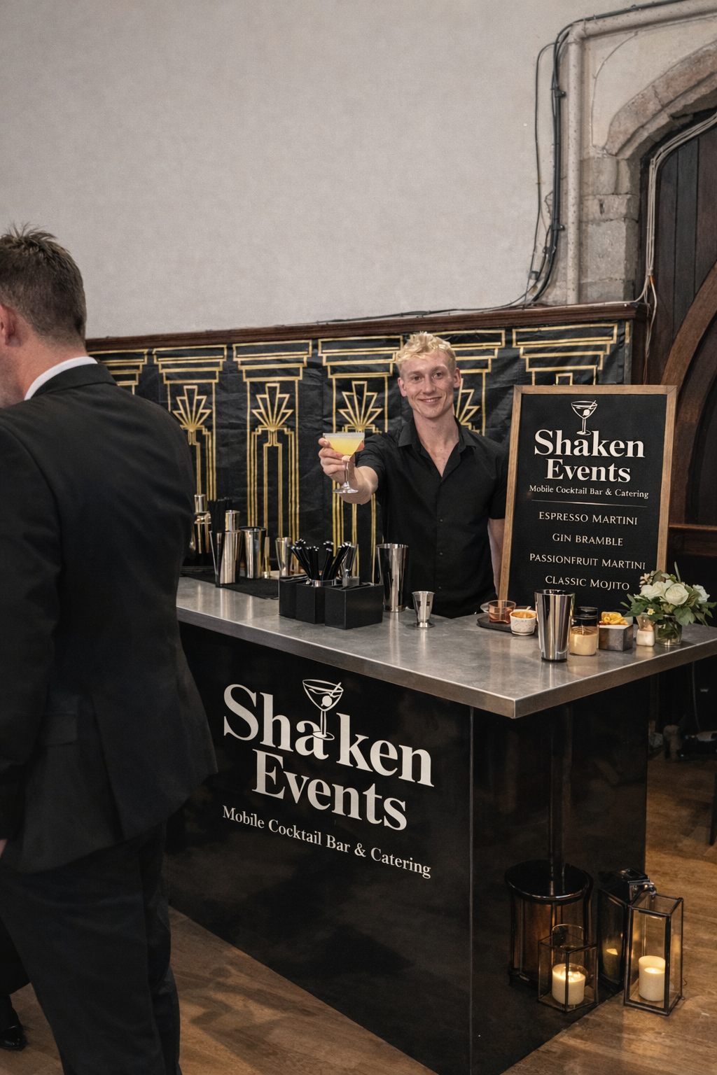 Professional bartender serving a yellow cocktail at a Shaken Events mobile bar for a formal event.