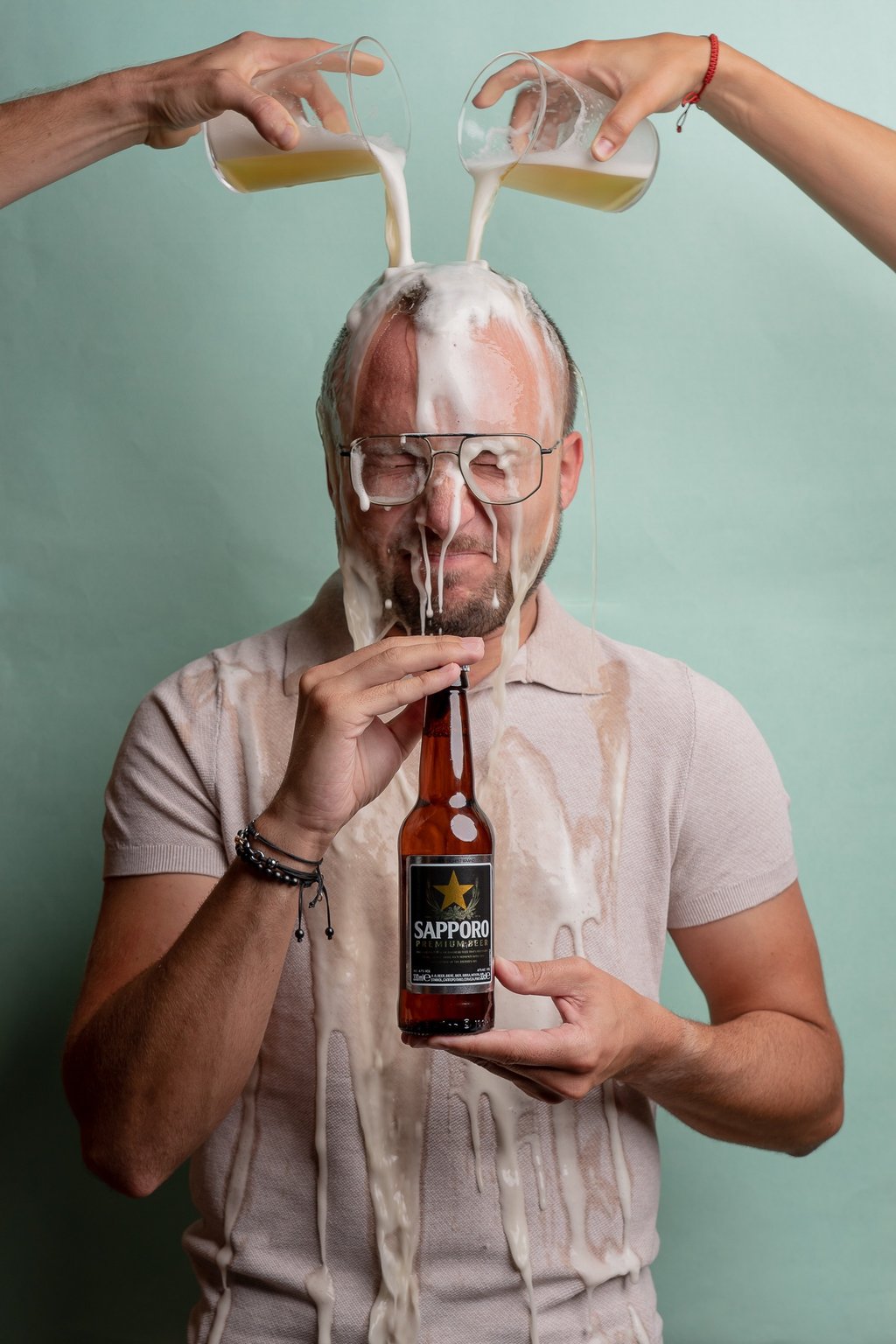 fotografía corporativa gastronómica de un hombre tirándose una cerveza sapporo por la cabeza