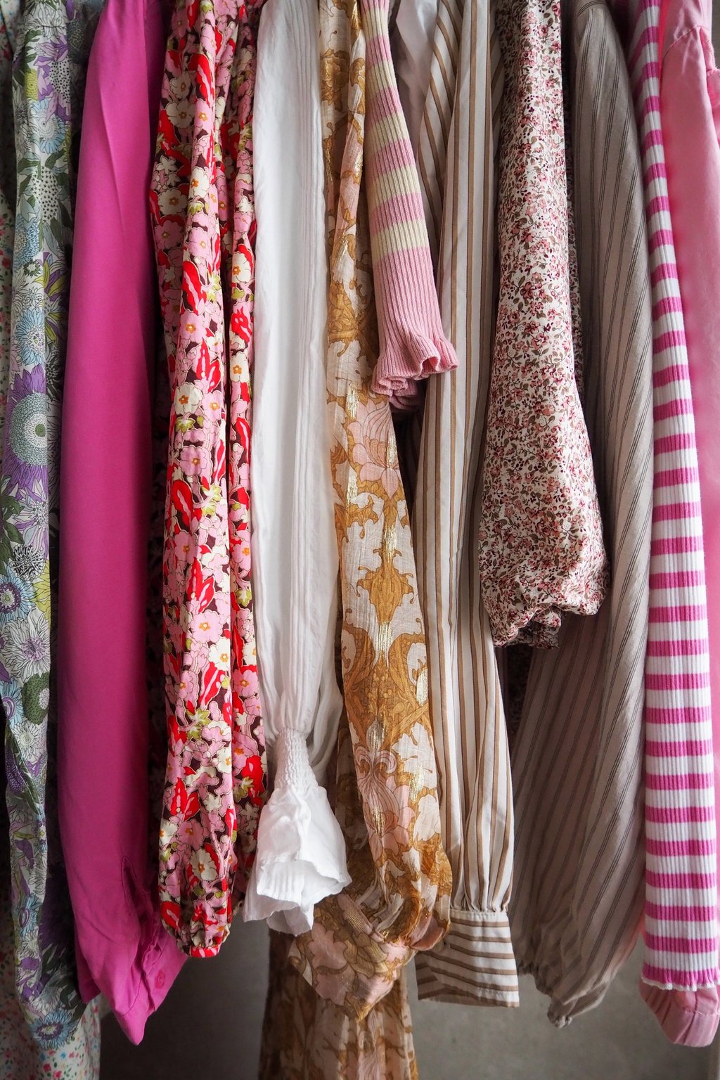 Kolorowe ubrania wiszą na wieszakach