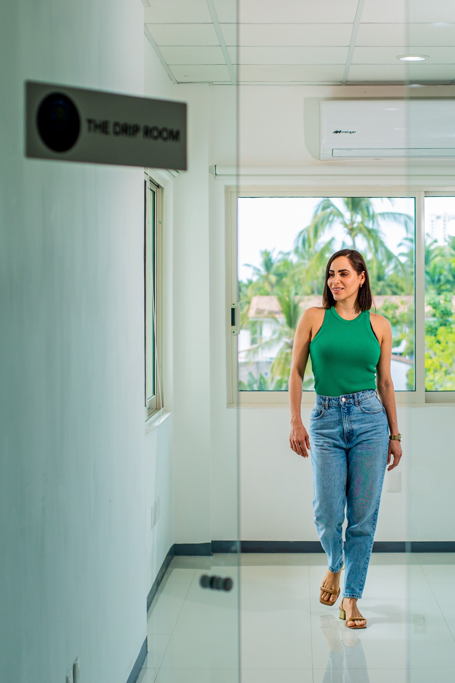 a woman in a green tank top and jeans jeans