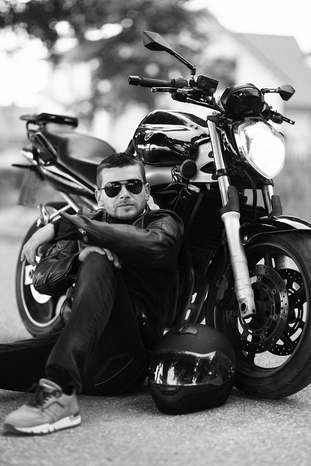 Audrius Turskas - a cool man sitting on the ground next to a motorcycle