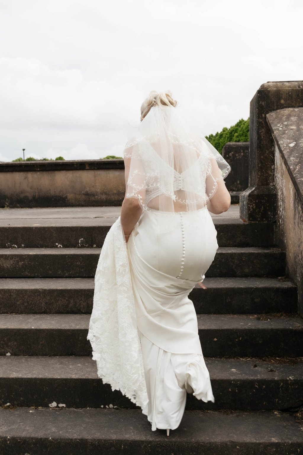 a bride in a white wedding dress and veil