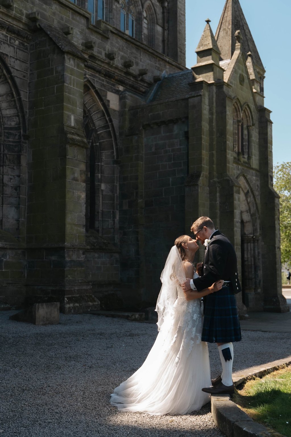 a bride and groom kissing in front of a church
