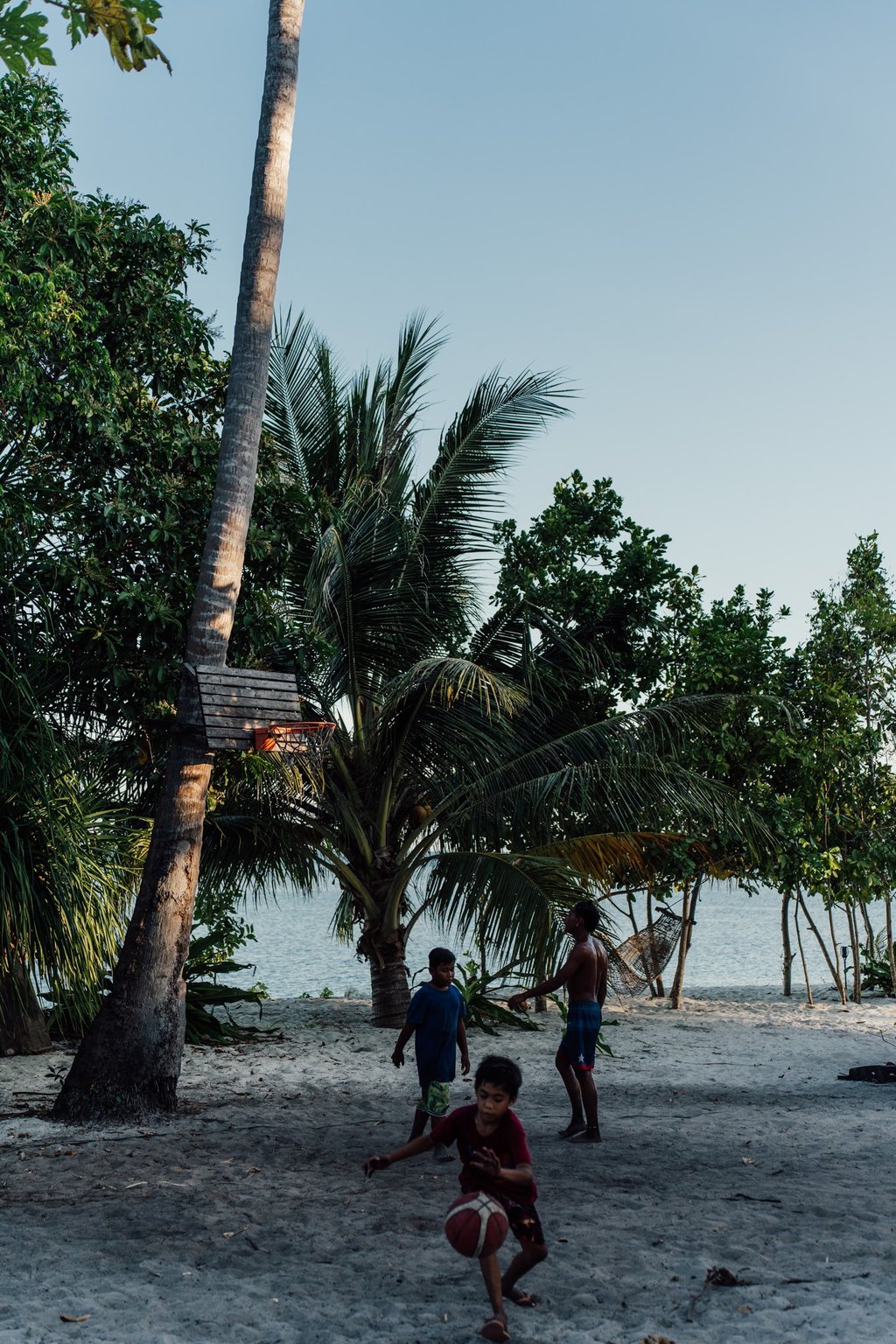 a group of people playing soccer on a sandy beach
