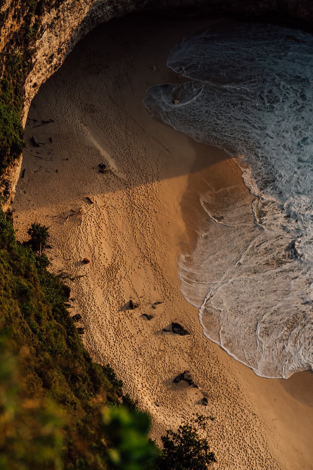 a person walking along a beach with a surfboard