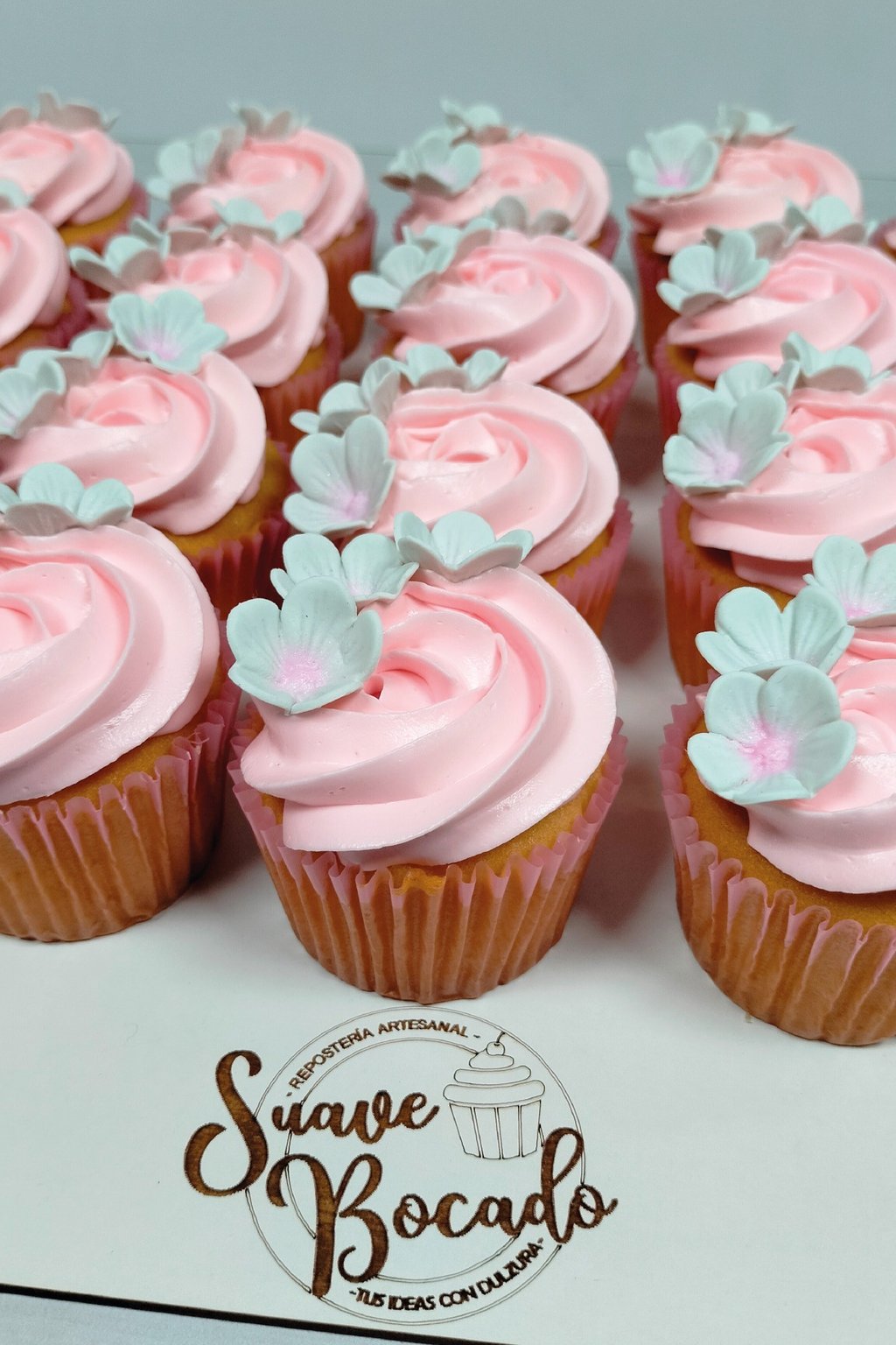 a bunch of cupcakes with pink frosting