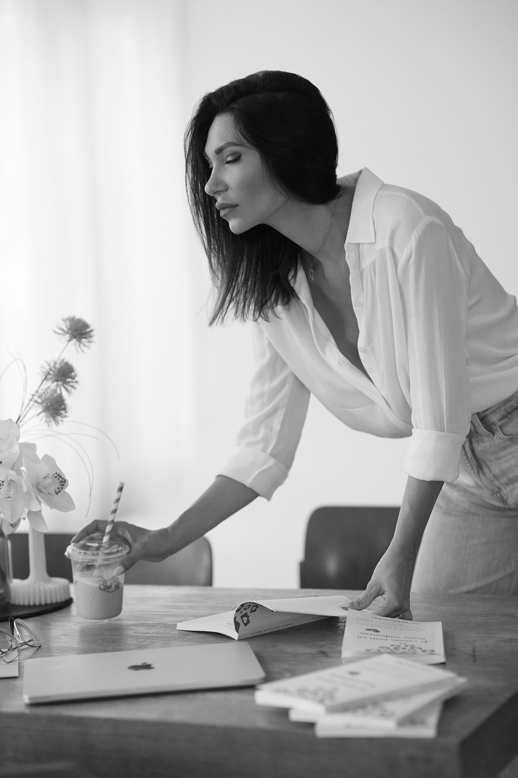 Portrait of the founder on a desk with books and laptop.