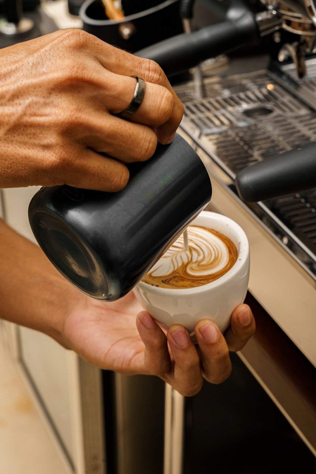 a person is pouring coffee into a cup 