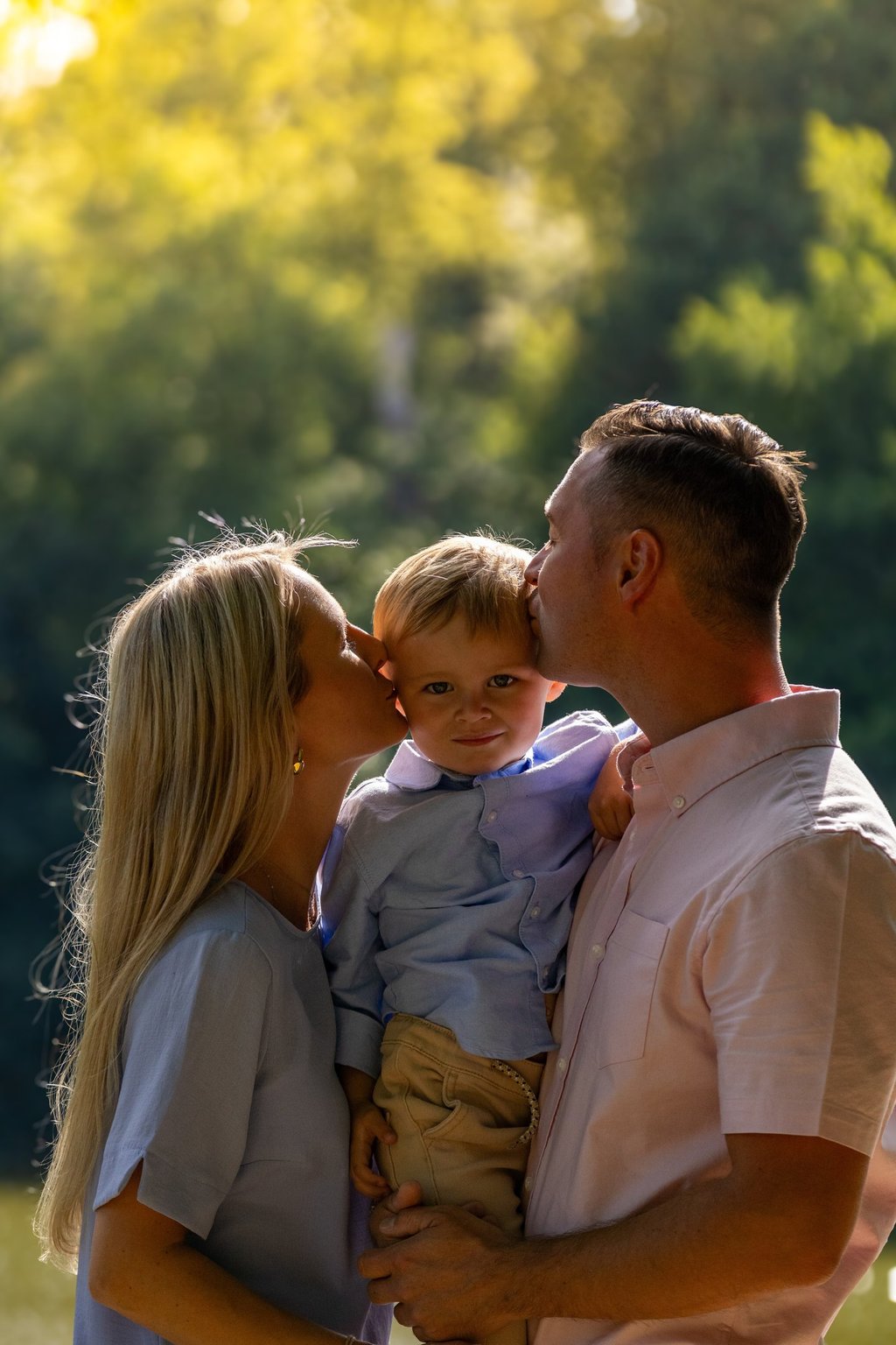 Familienshooting Coburg: Glücklicher Moment, Eltern geben ihrem Sohn einen Kuss auf die Wange.