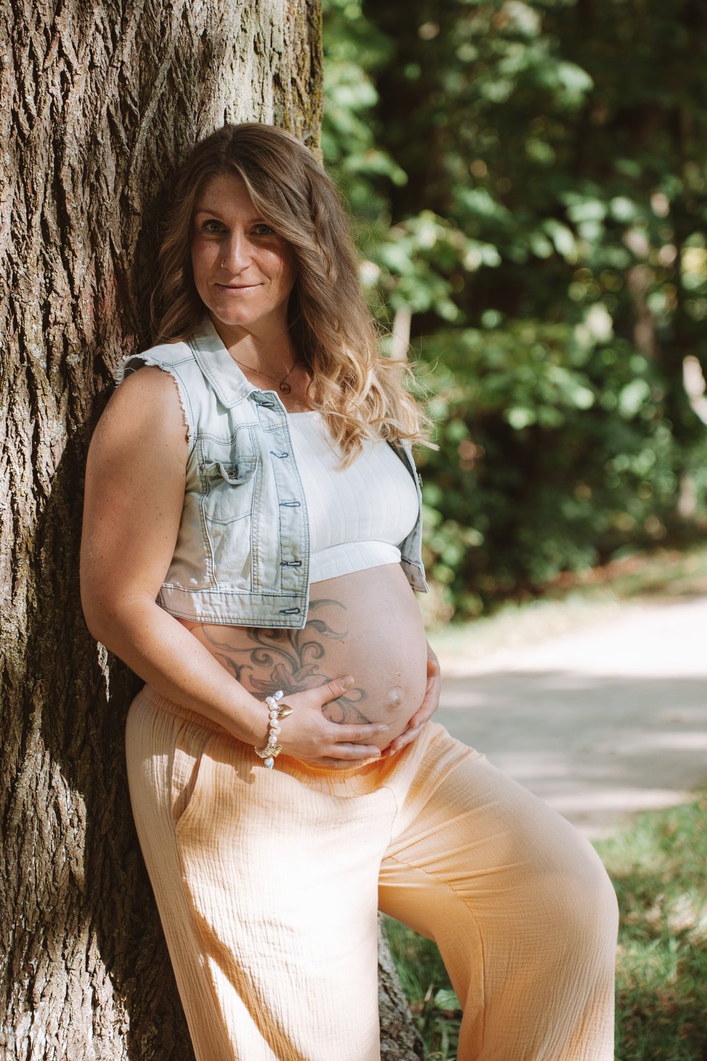 Babybauchshooting Coburg: Stolze werdende Mutter hält schützend die Hände auf ihren Bauch.