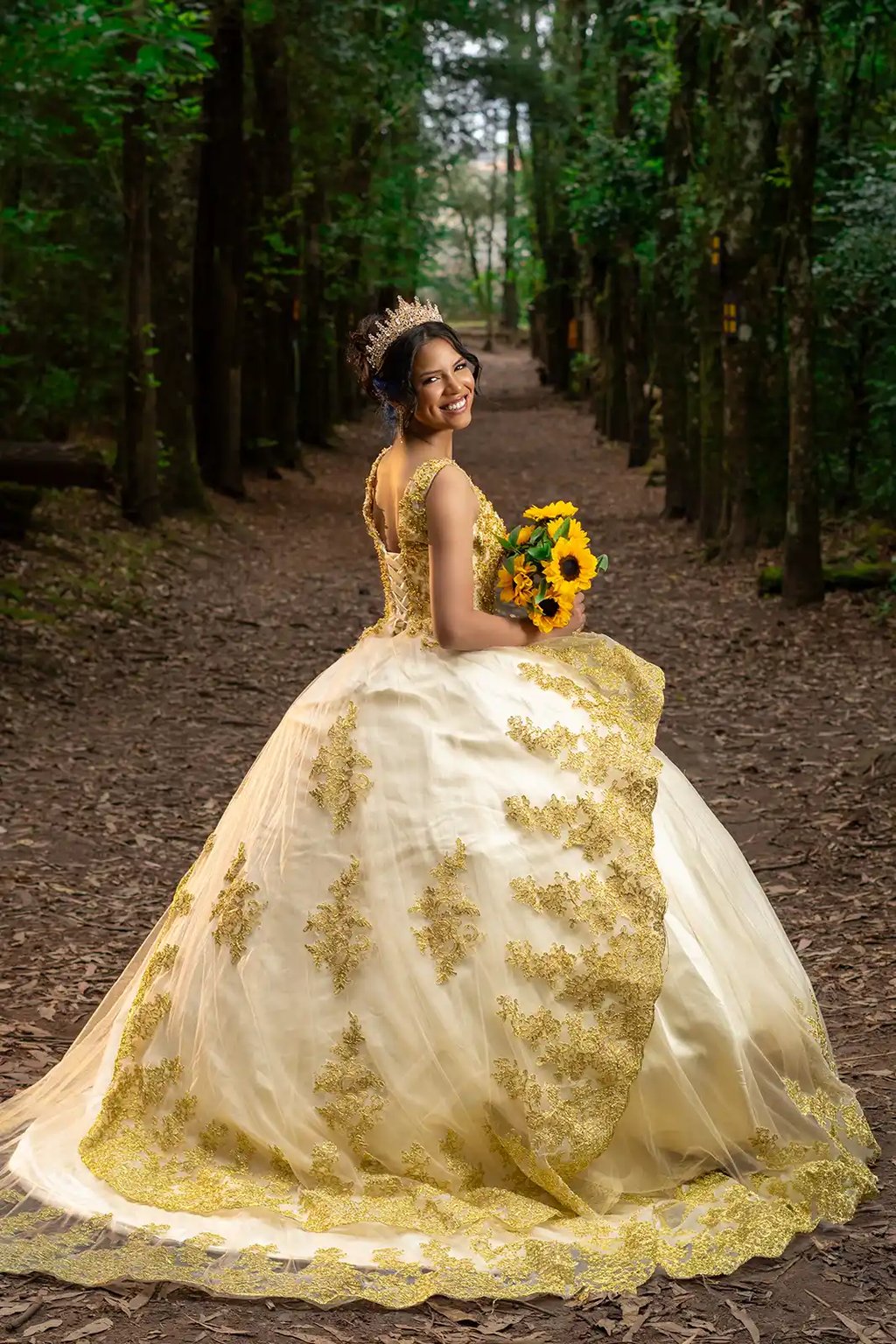 Retrato editorial de quinceañera en bosque de Quito con vestido dorado. Iluminación cinematográfica premium