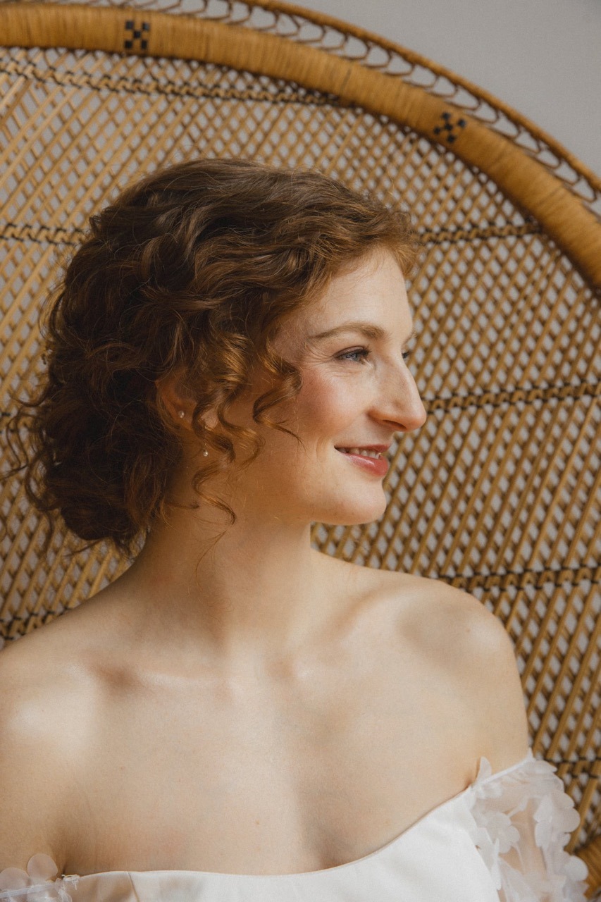 Une mariée rousse heureuse regarde vers l'extérieur.