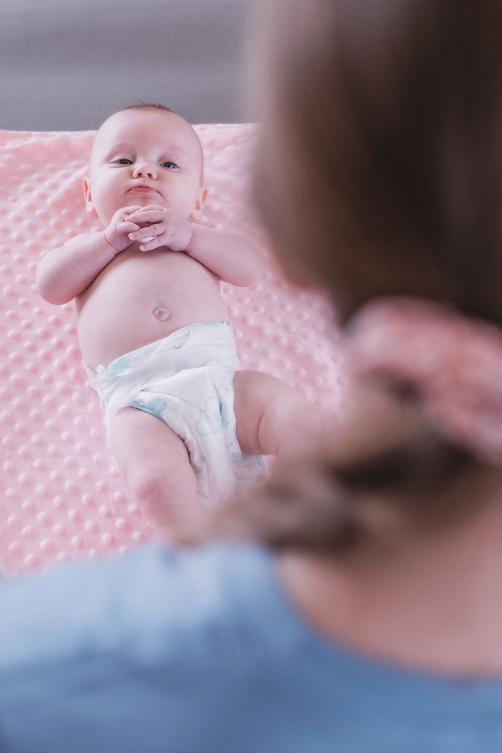 Baby lying on a pink blanket during a Rock & Roll Baby massage class in Radwinter near Saffron Walden