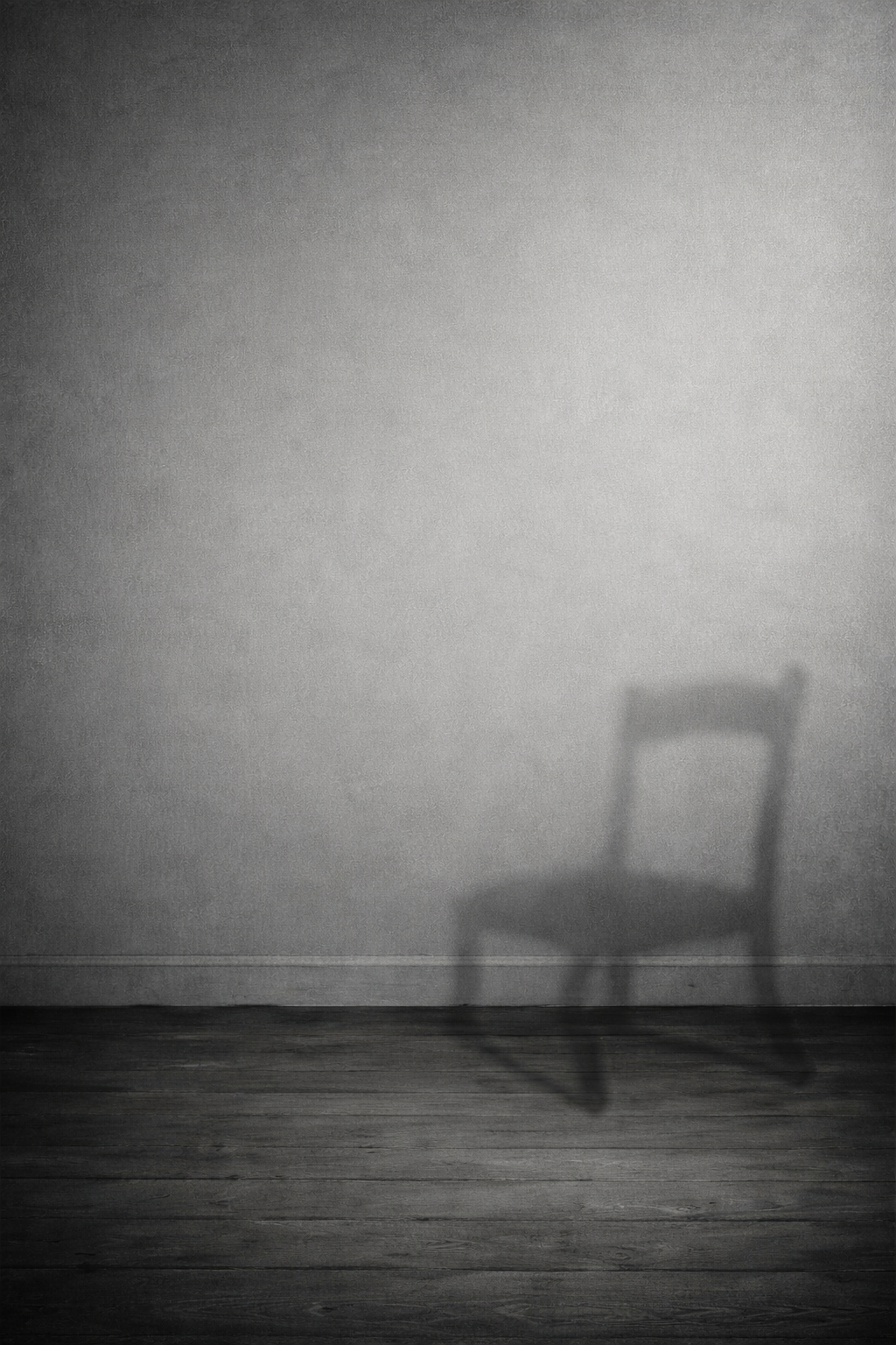 Minimalist black and white image of a chair casting a shadow