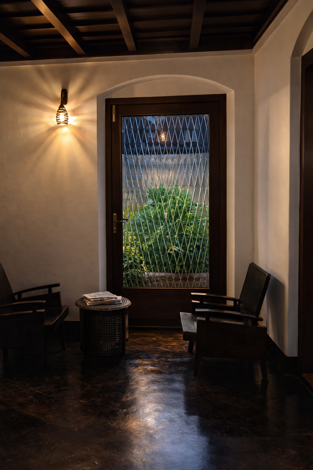 Elegant room with dark wood furniture, warm wall sconce lighting, and a glass door overlooking a garden.