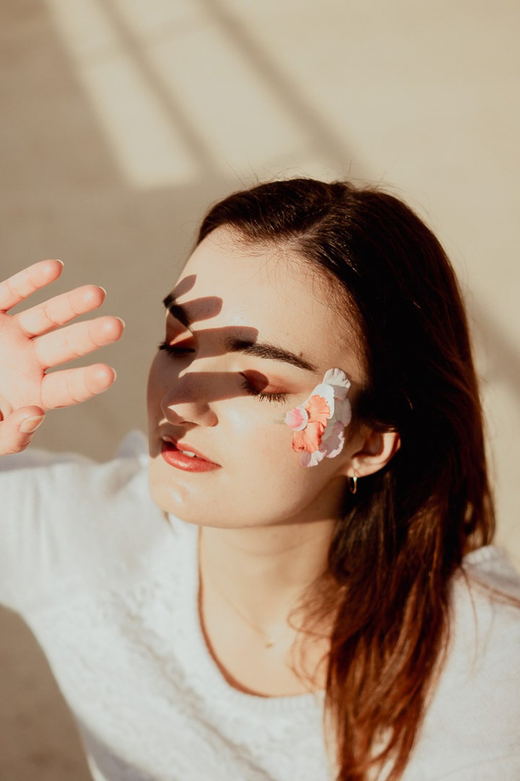 portrait féminin cachant son visage du soleil avec sa main