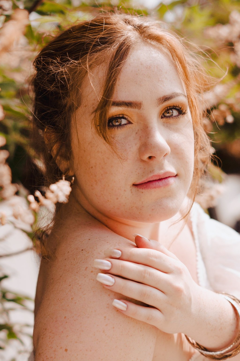 portrait rapproché féminin regardant l'objectif main gauche sur épaule droite