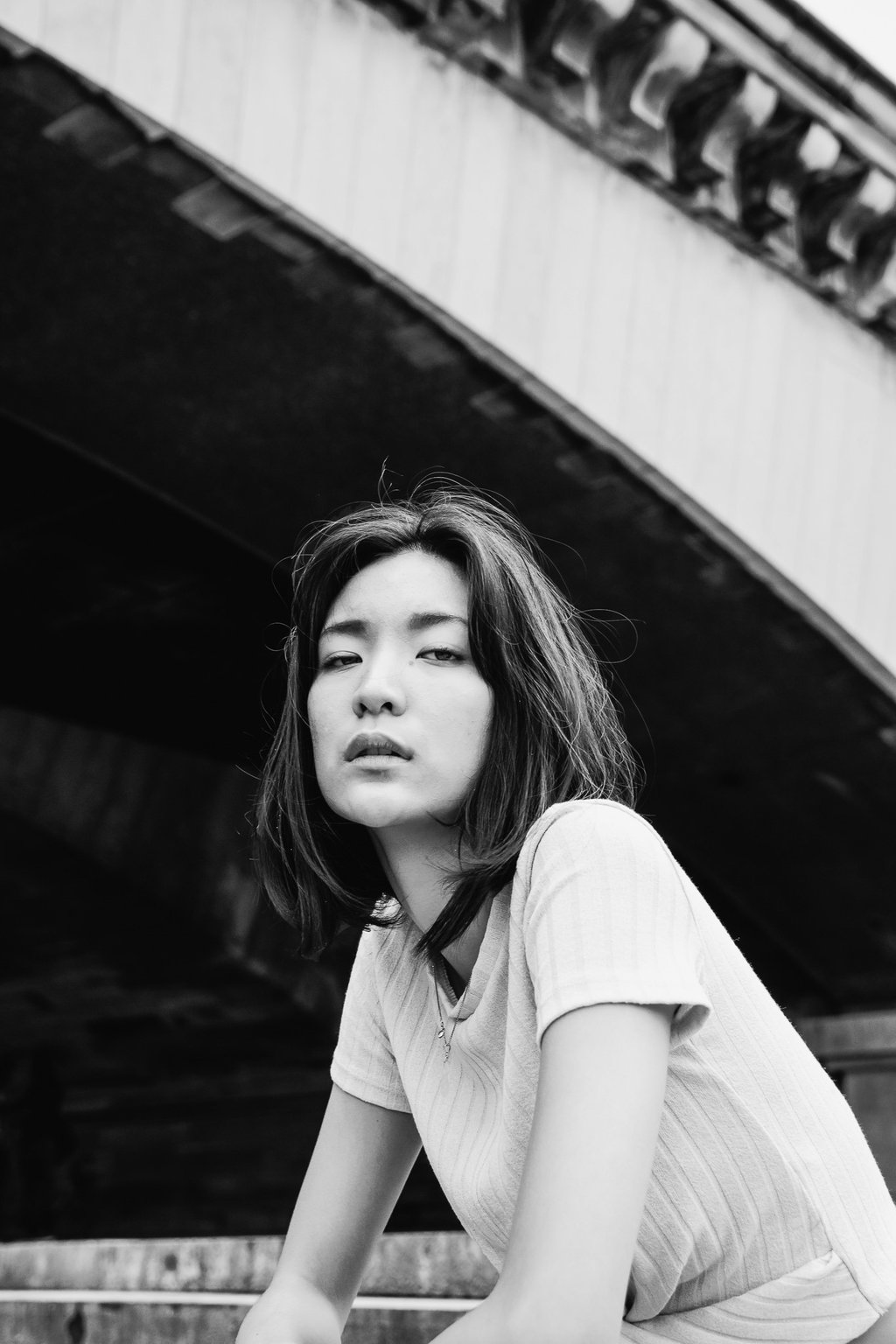 portrait féminin en noir et blanc regardant l'objectif en extérieur