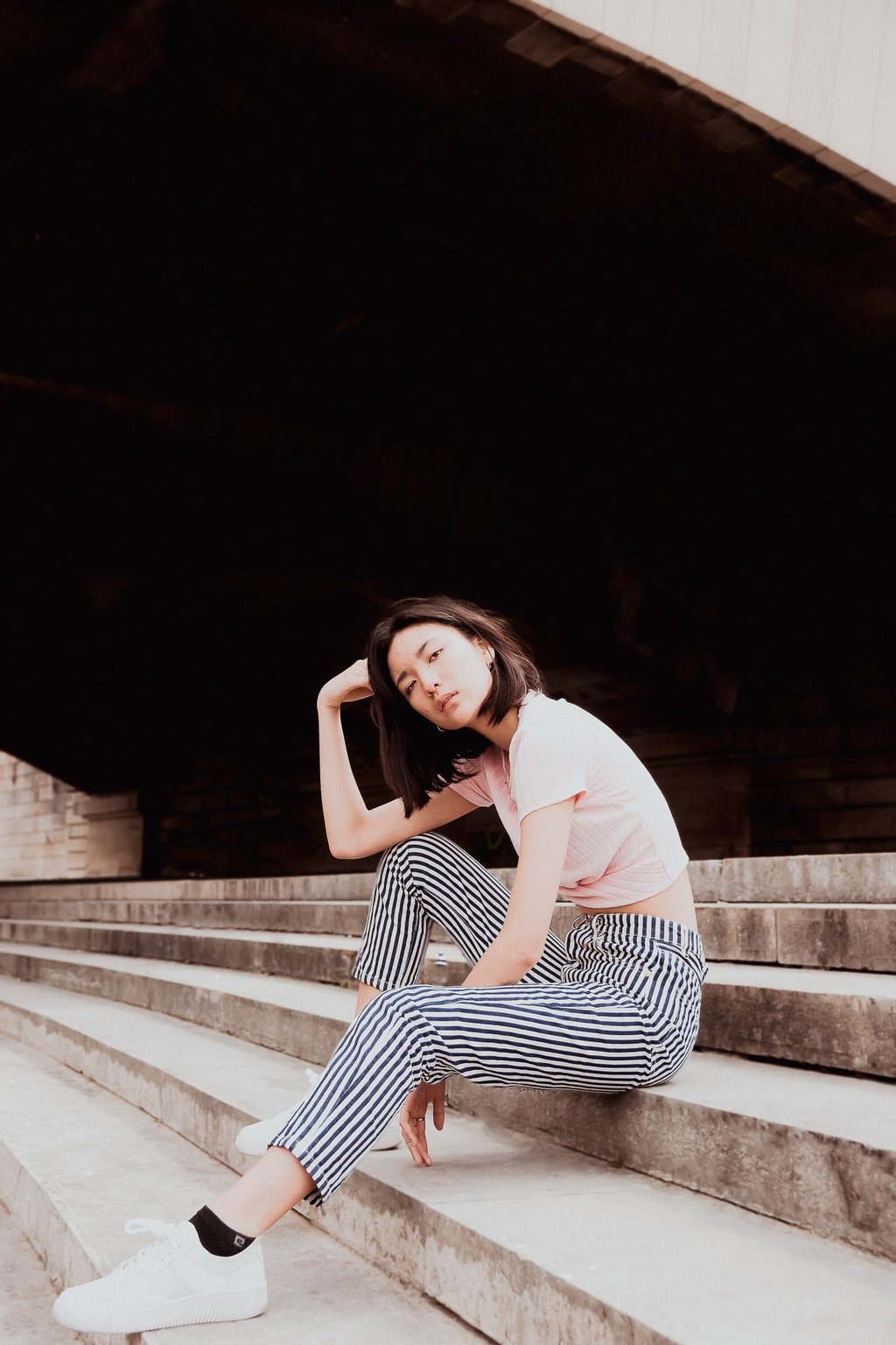 portrait de femme assises sur des escaliers couleurs douces
