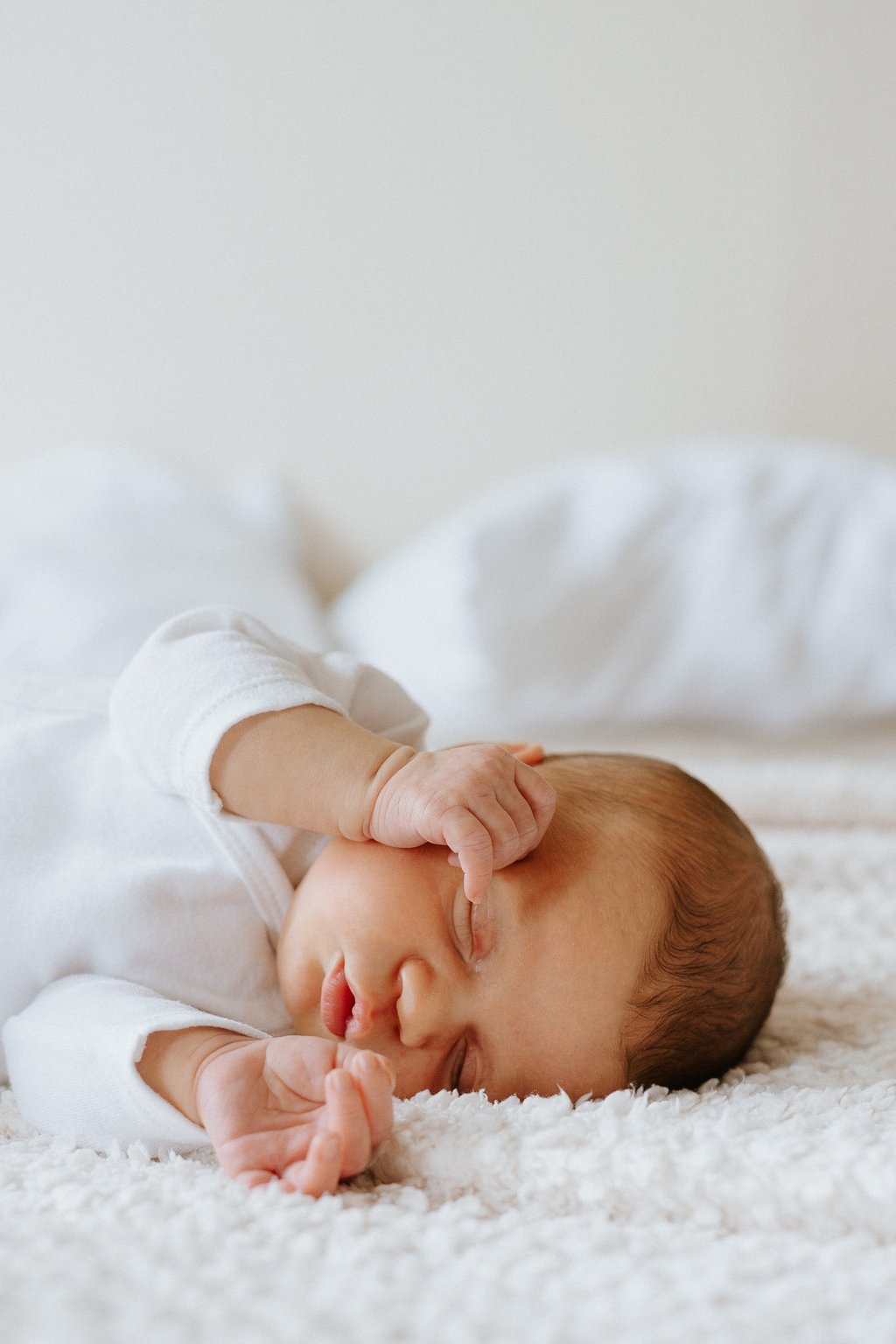 portrait de nouveau né amenant ses mains au visage