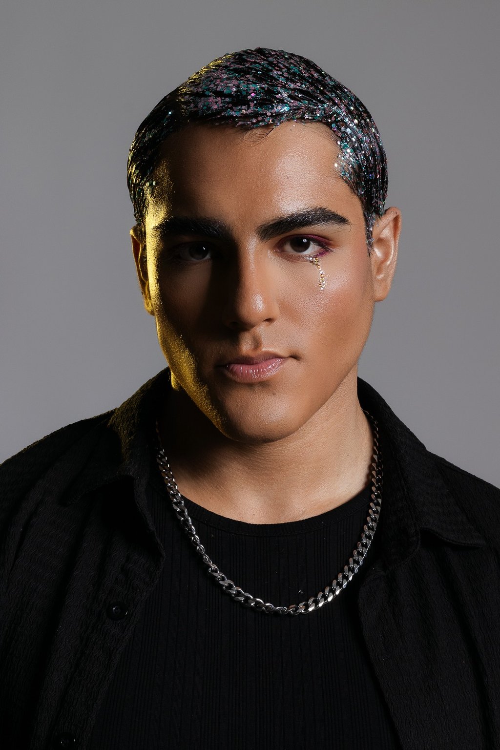 Retrato de moda para hombres en Cancún. Modelo masculino con cadena de plata en estudio.