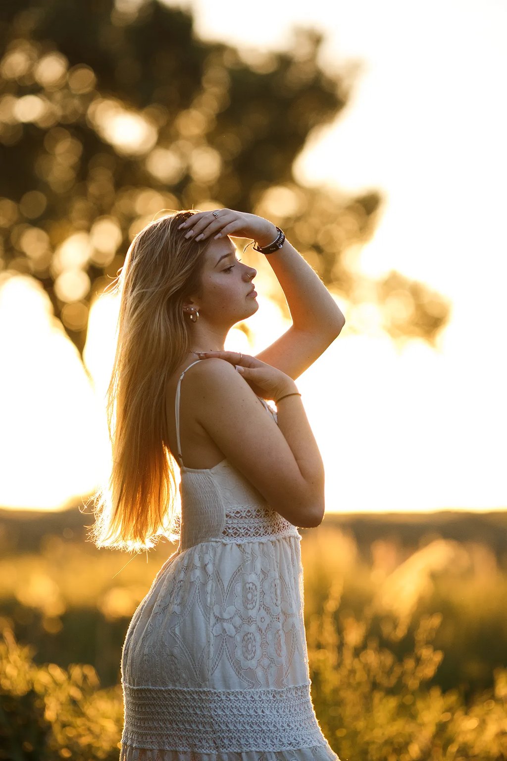 une jeune femme dans un champ au coucher du soleil