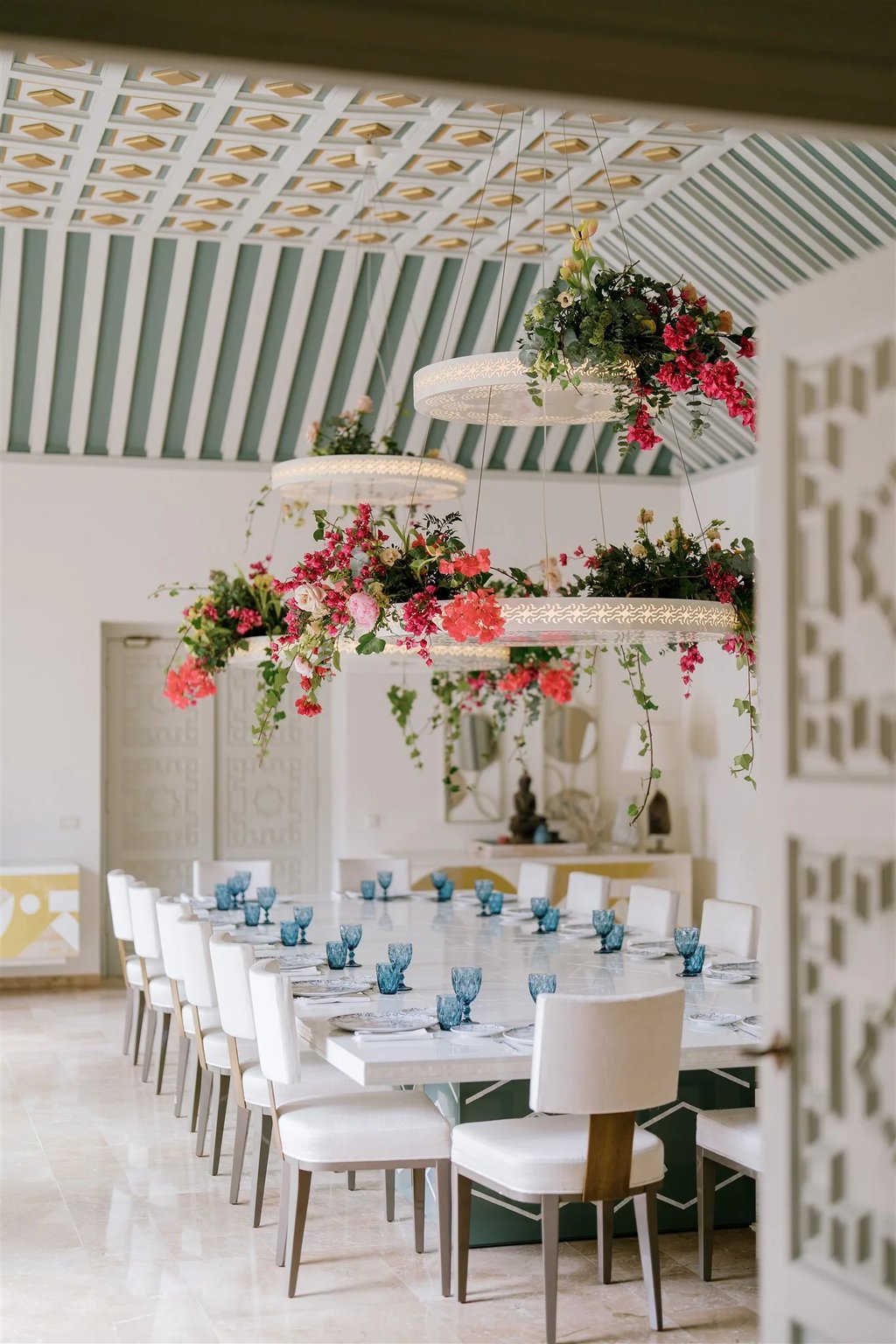 Grand dining room with floral chandeliers and patterned vaulted ceiling