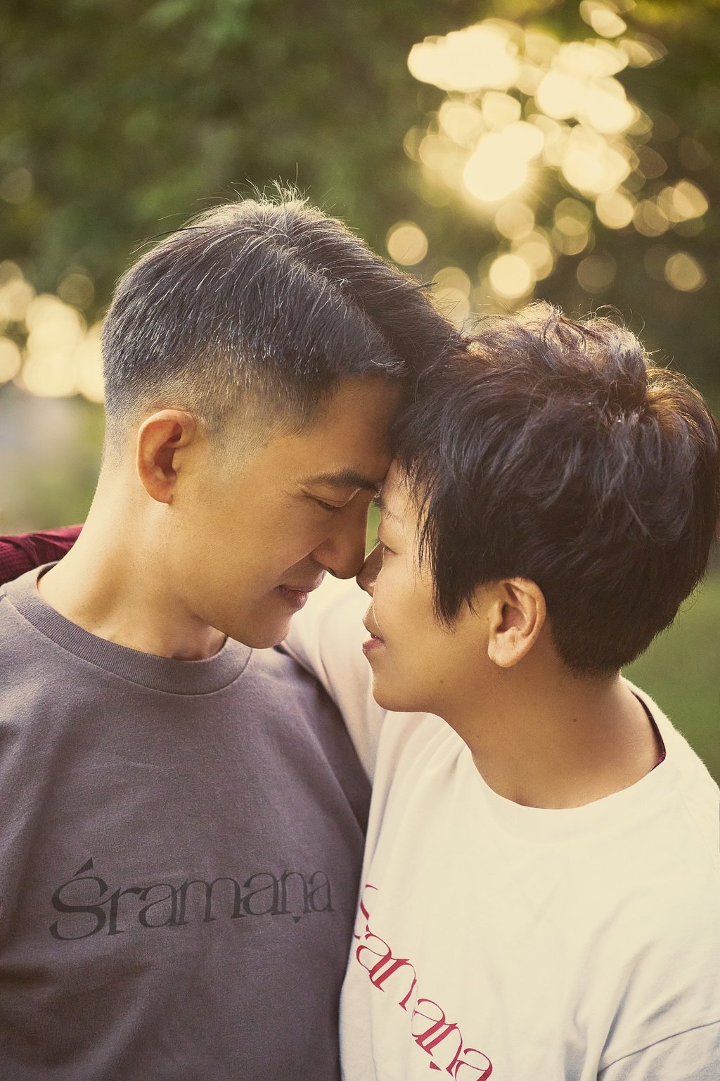 Happy Asian couple touching foreheads during a romantic outdoor sunset date.