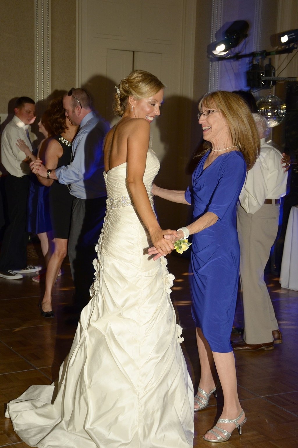 a bride and her mother dancing at a wedding in a hotel ball room