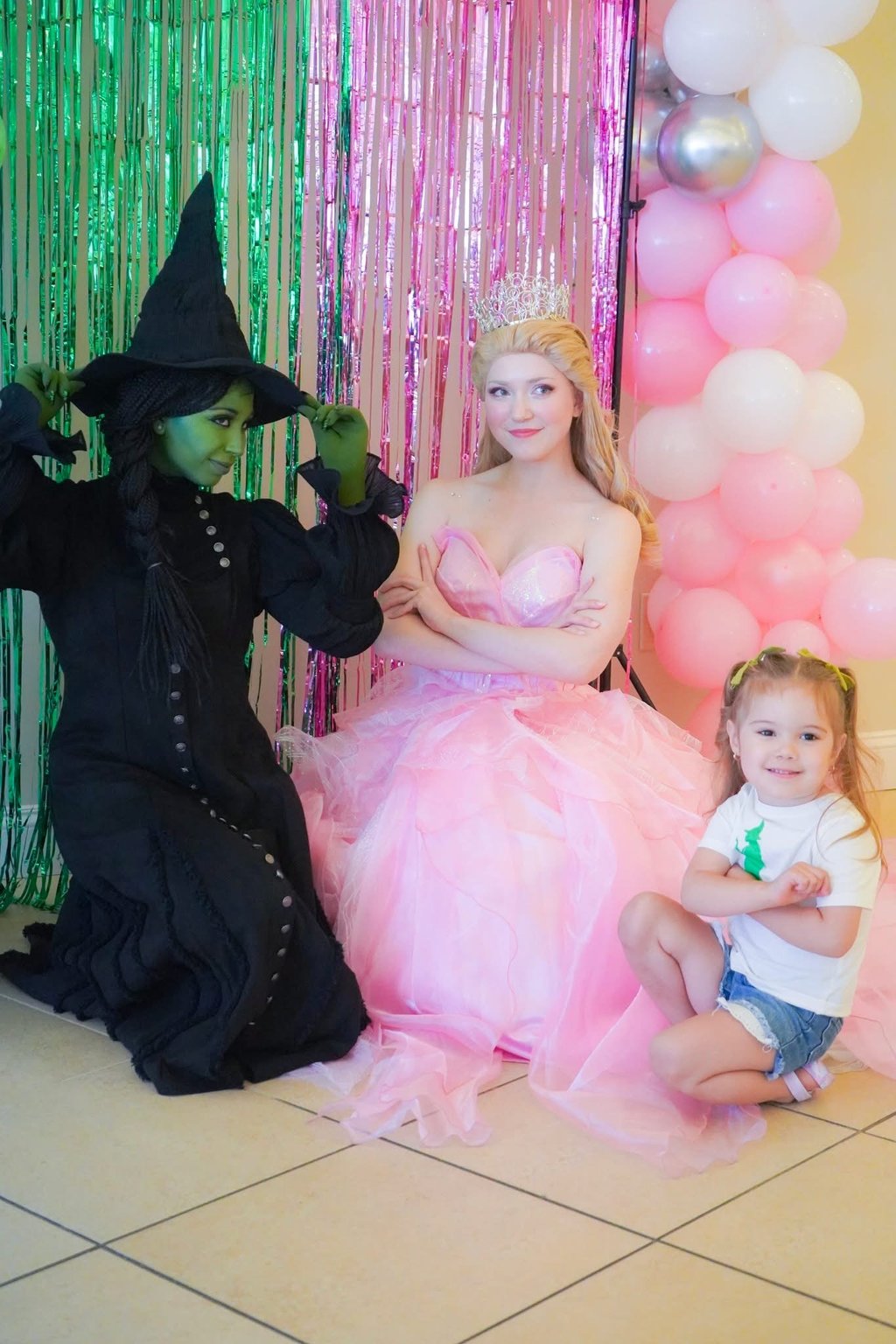 Elphaba and Glind pose with a child