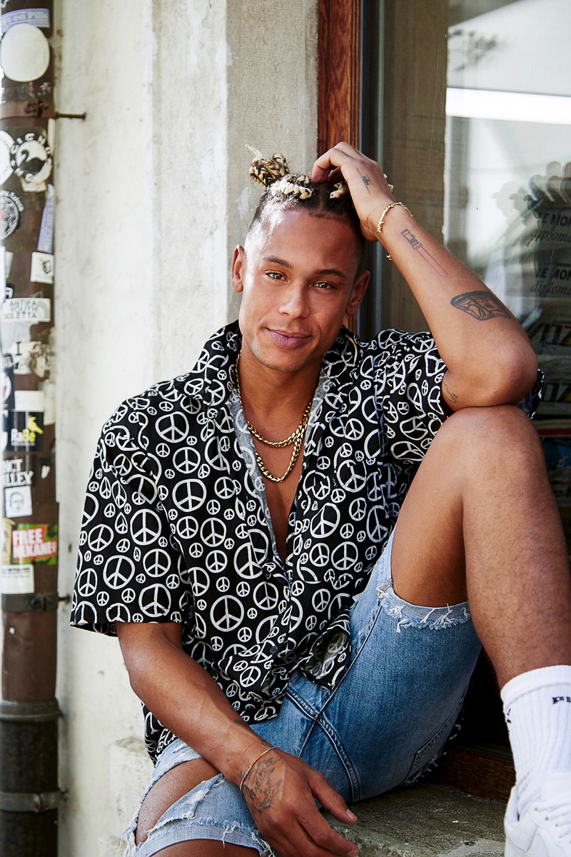 a man sitting on a ledge with a peace sign