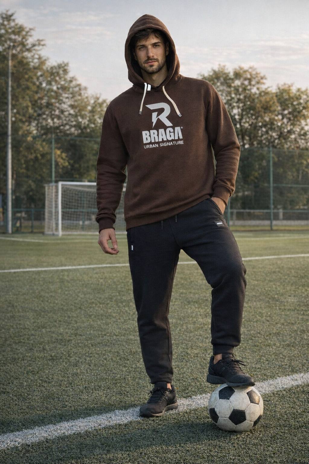 vyras futbolo aikštėje vilkintis laisvalaikio kostiumu