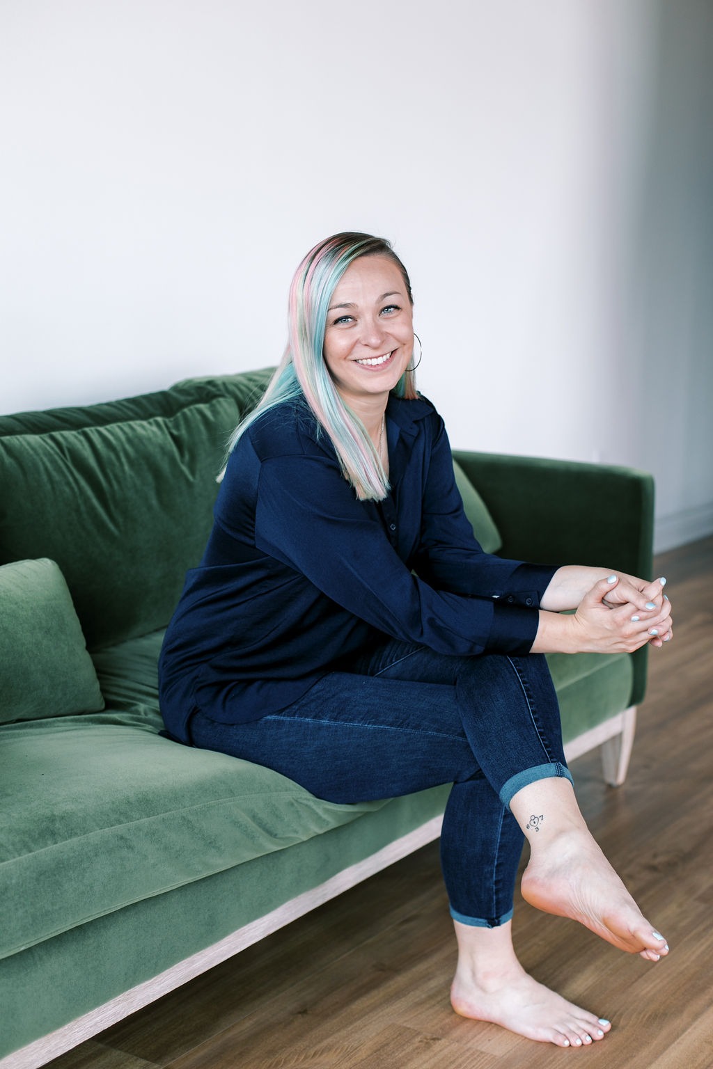 Tabitha with butterfly effect consulting sitting on a couch with her feet on the floor