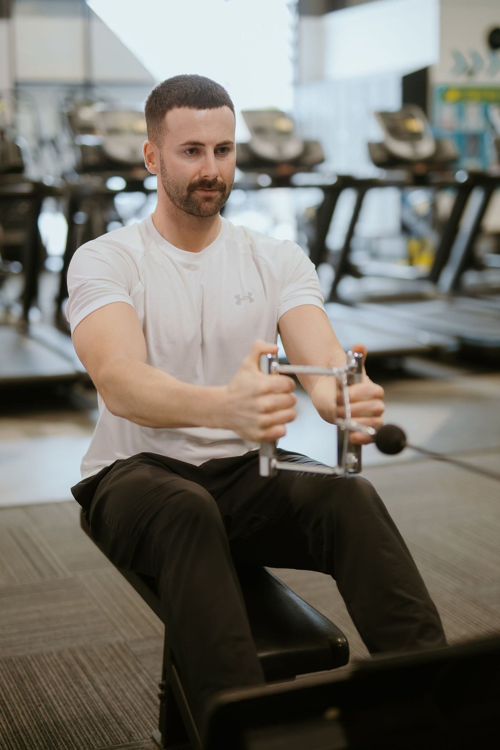 Person performing weighted row in Leamington Spa gym, focused on strength and back activation