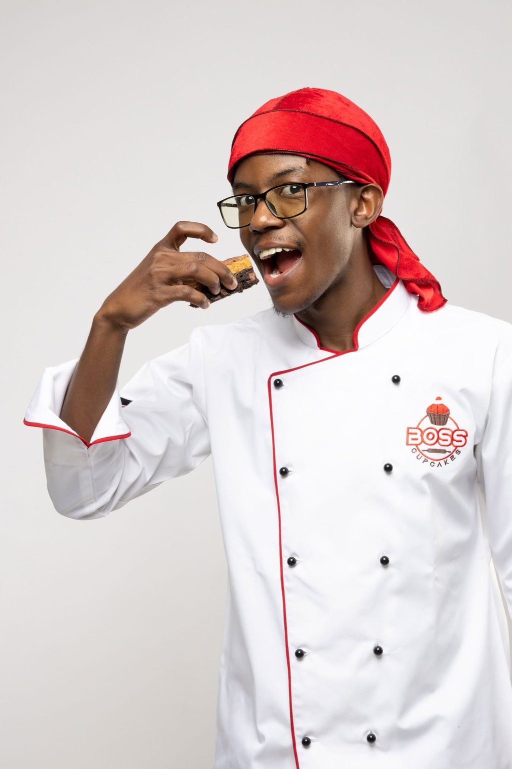 a man in a chef's uniform is holding a cookie