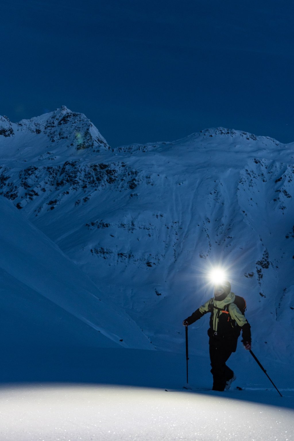 Ski touring skier wearing a Silva headlamp at dawn in alpine terrain