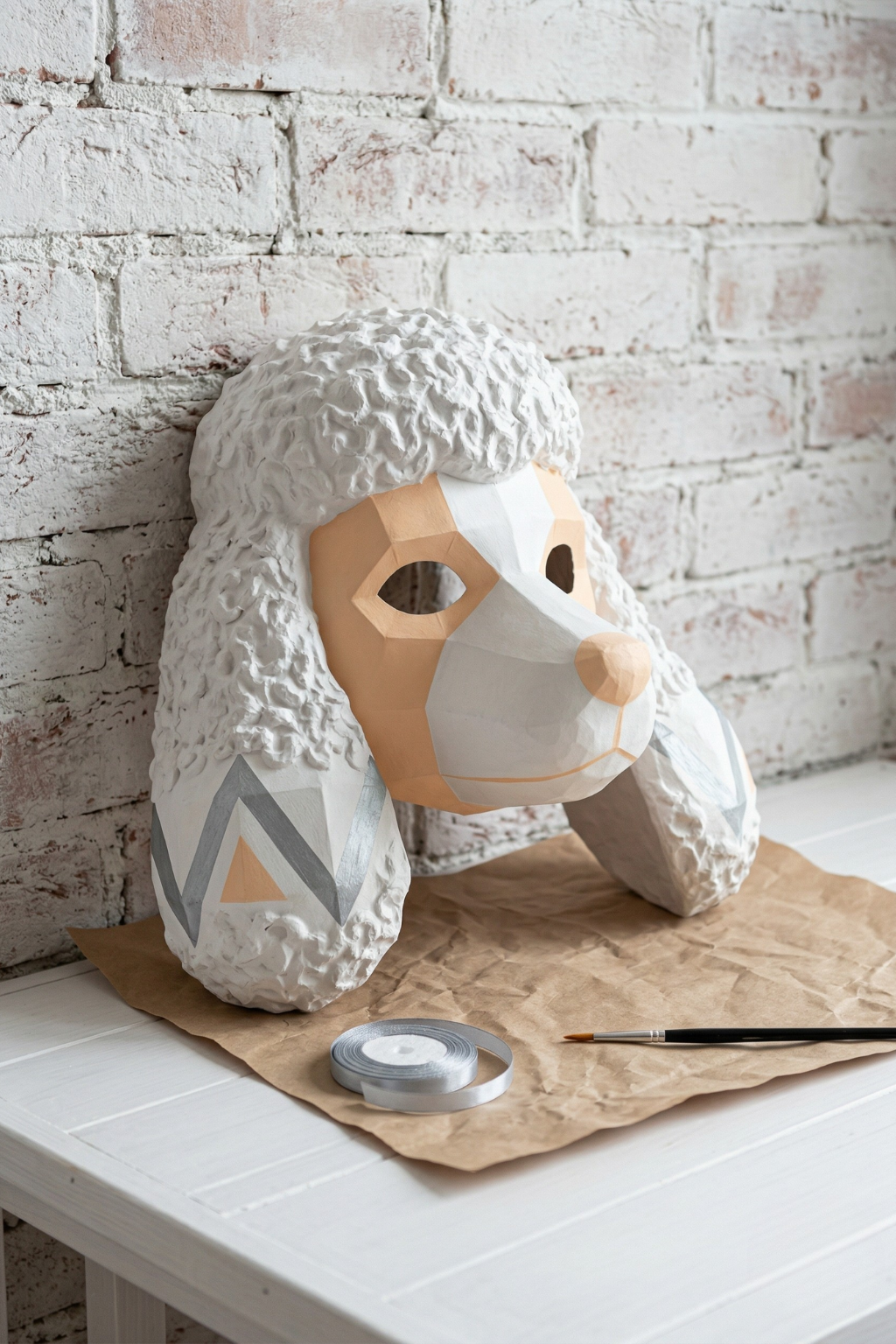 Handmade white poodle paper mache mask on a workbench with DIY craft supplies.