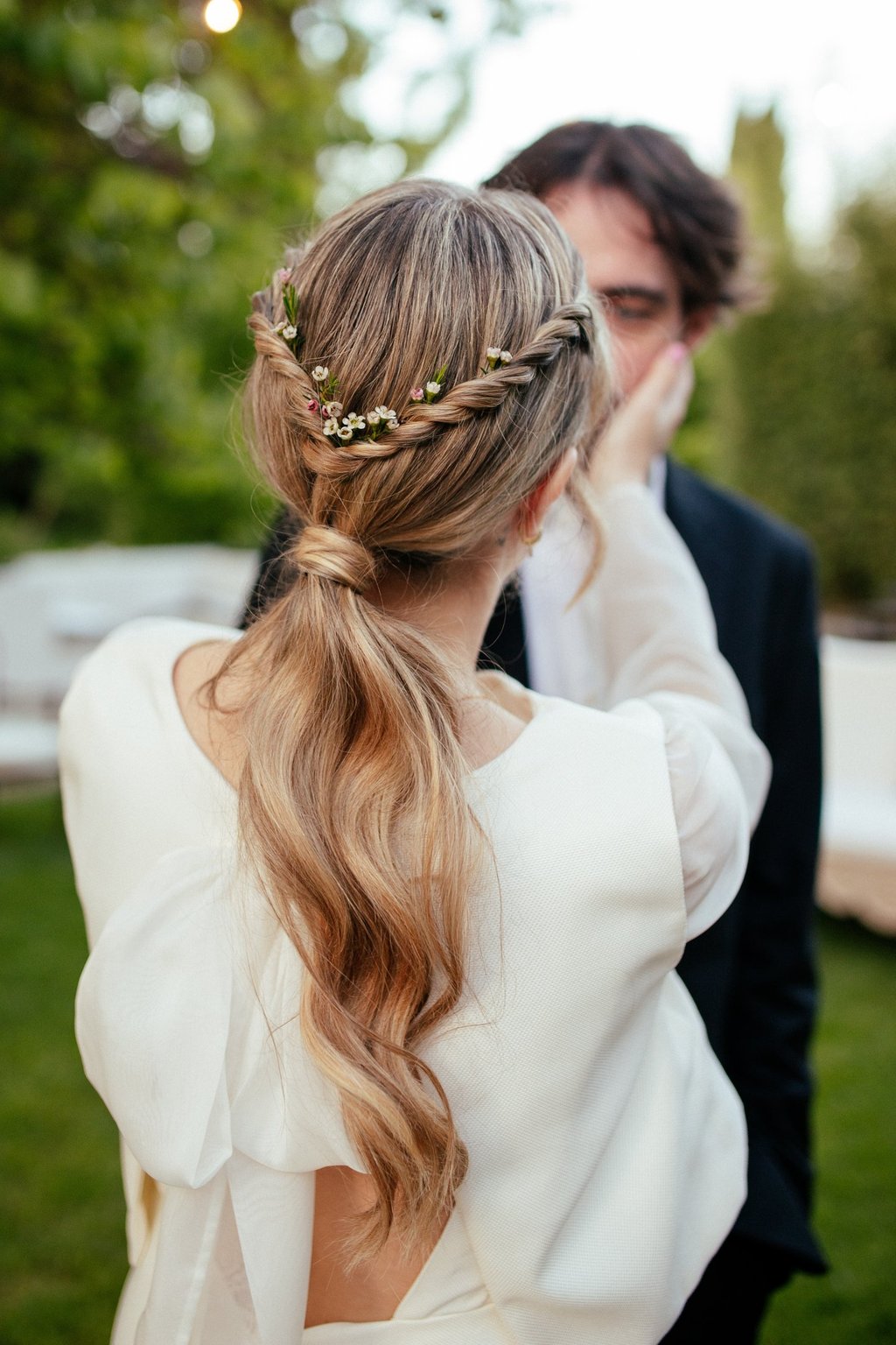 Bride with effortless natural ponytail decorated with natural flowers during wedding in Portugal