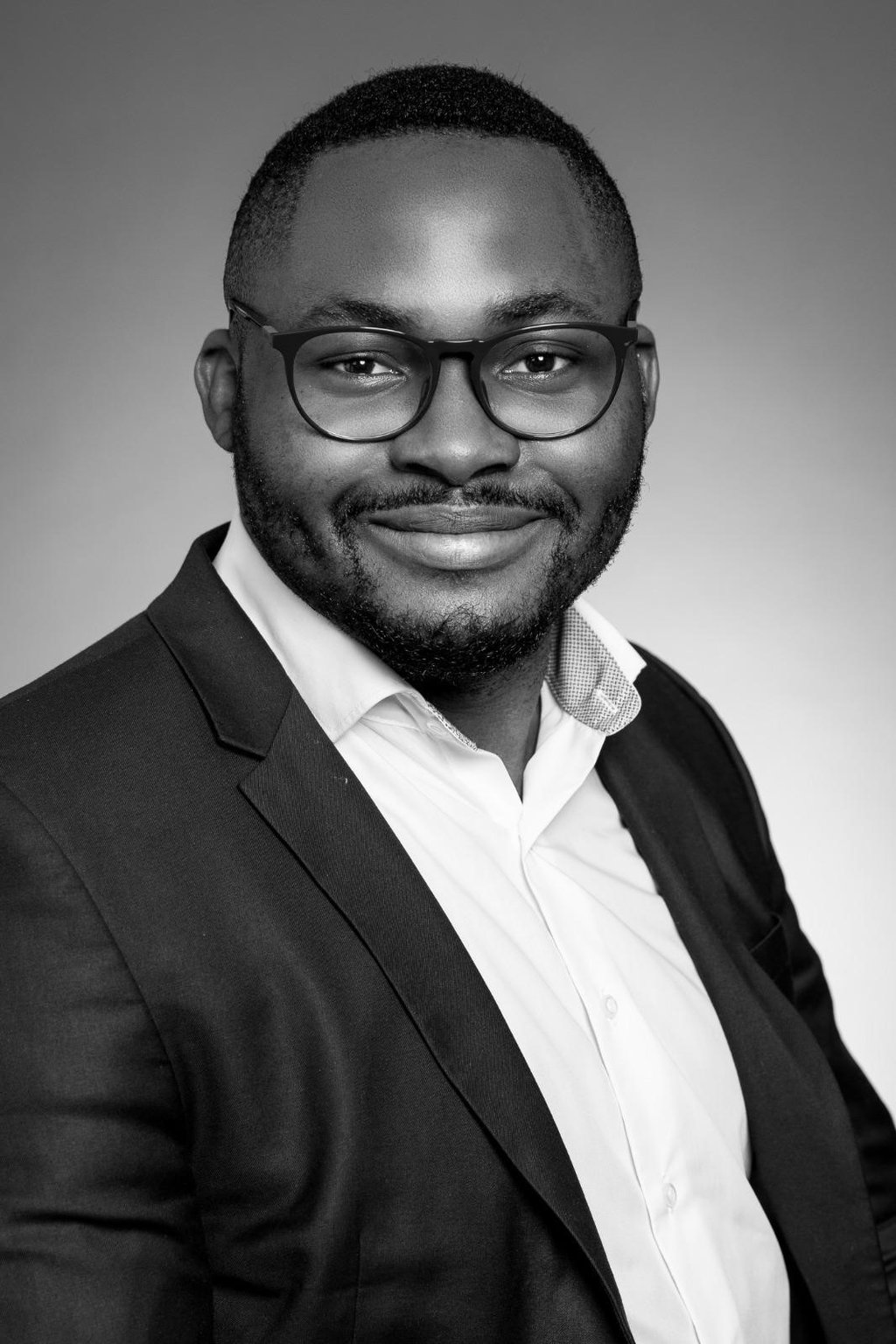 a man in a suit and glasses smiling