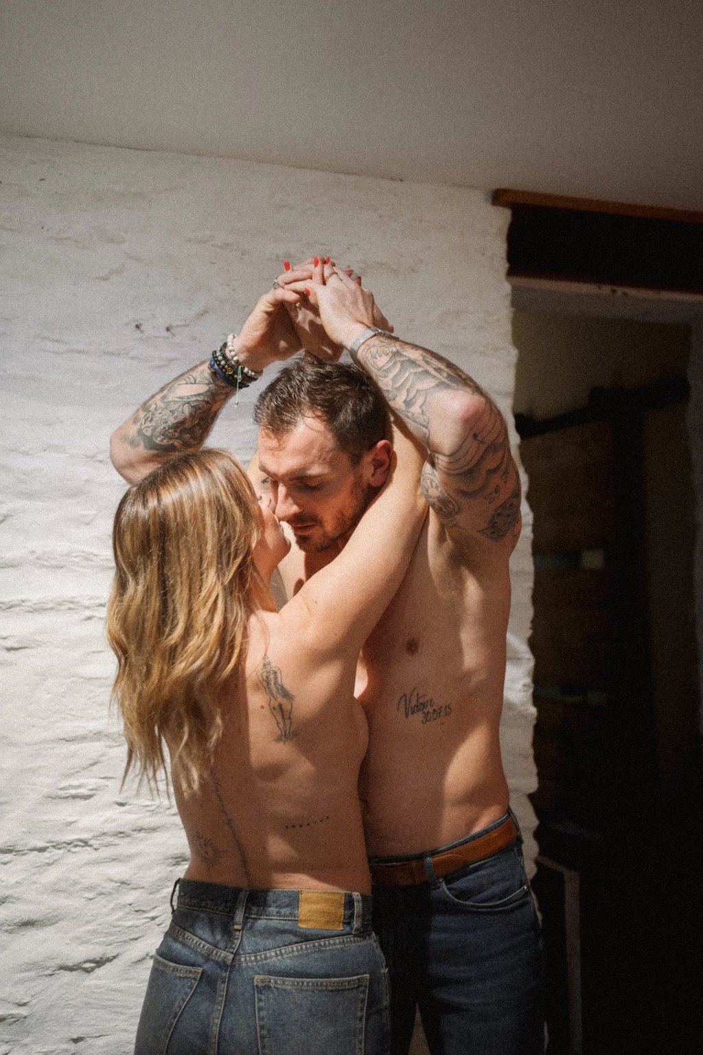 Couple tatoué s’embrassant lors d’une séance photo de couple intimiste