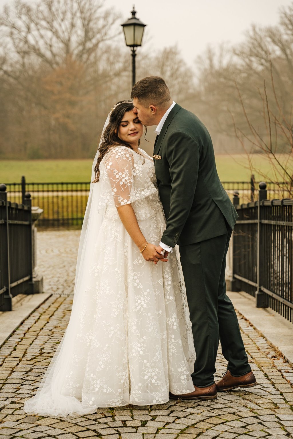 panna młoda i pan młody stojący na ceglanym chodniku